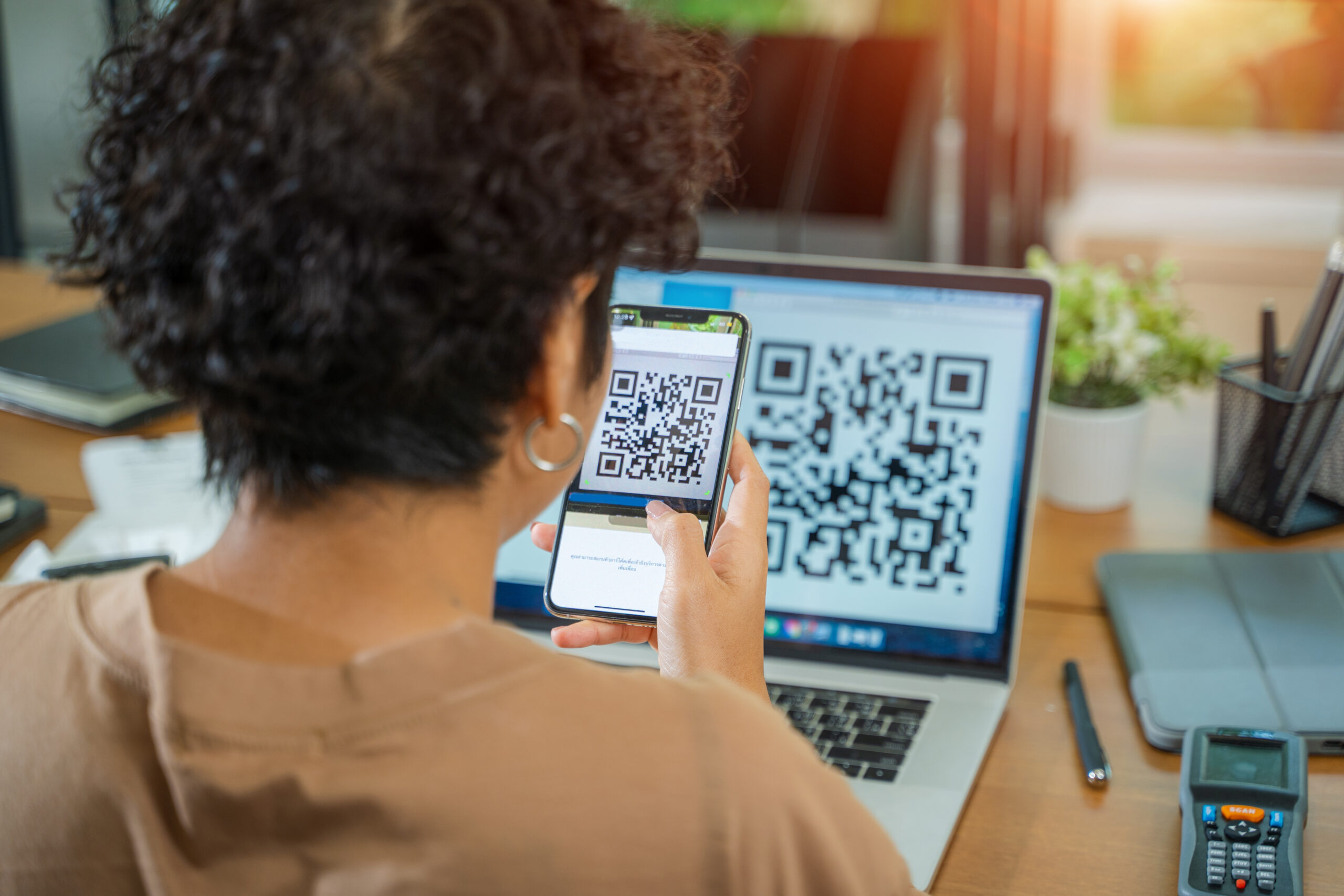 woman scanning a QR code after learning about QR code scams