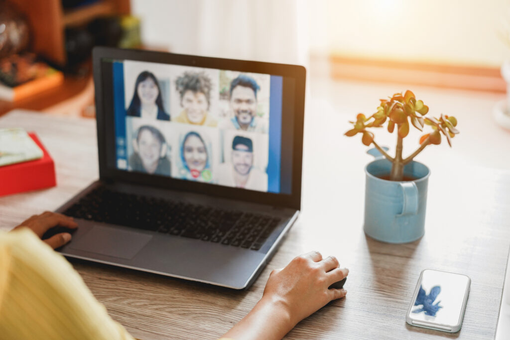 Young woman having a discussion meeting in video call with her team work - Focus on right hand